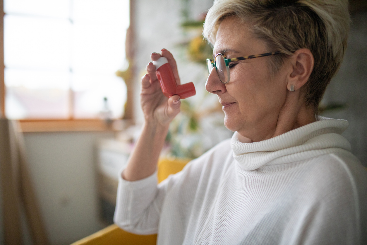 Frau zu Hause mit ihrem Asthma-Inhalator &ndash; Dauermedikation bequem online bestellt